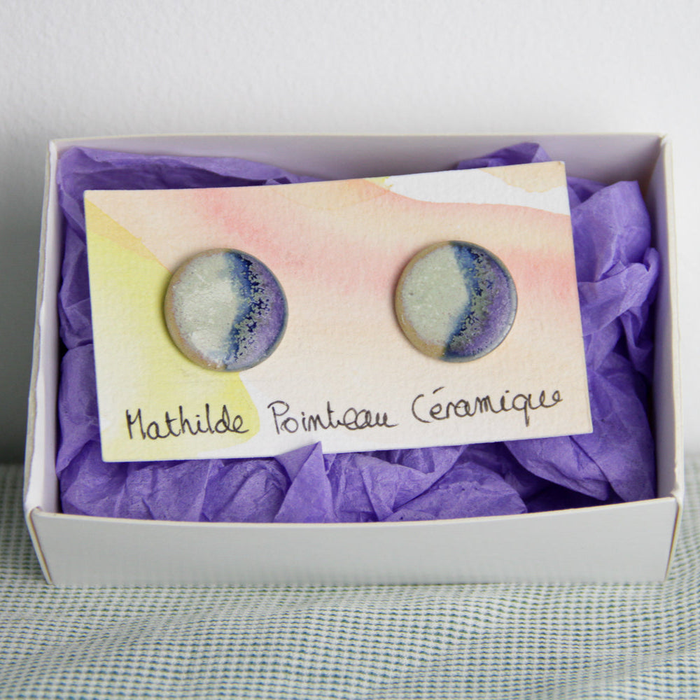 Boucle d'oreille en céramique dans son packaging. Les puces d'oreilles sont bicolore menthe et violette.
