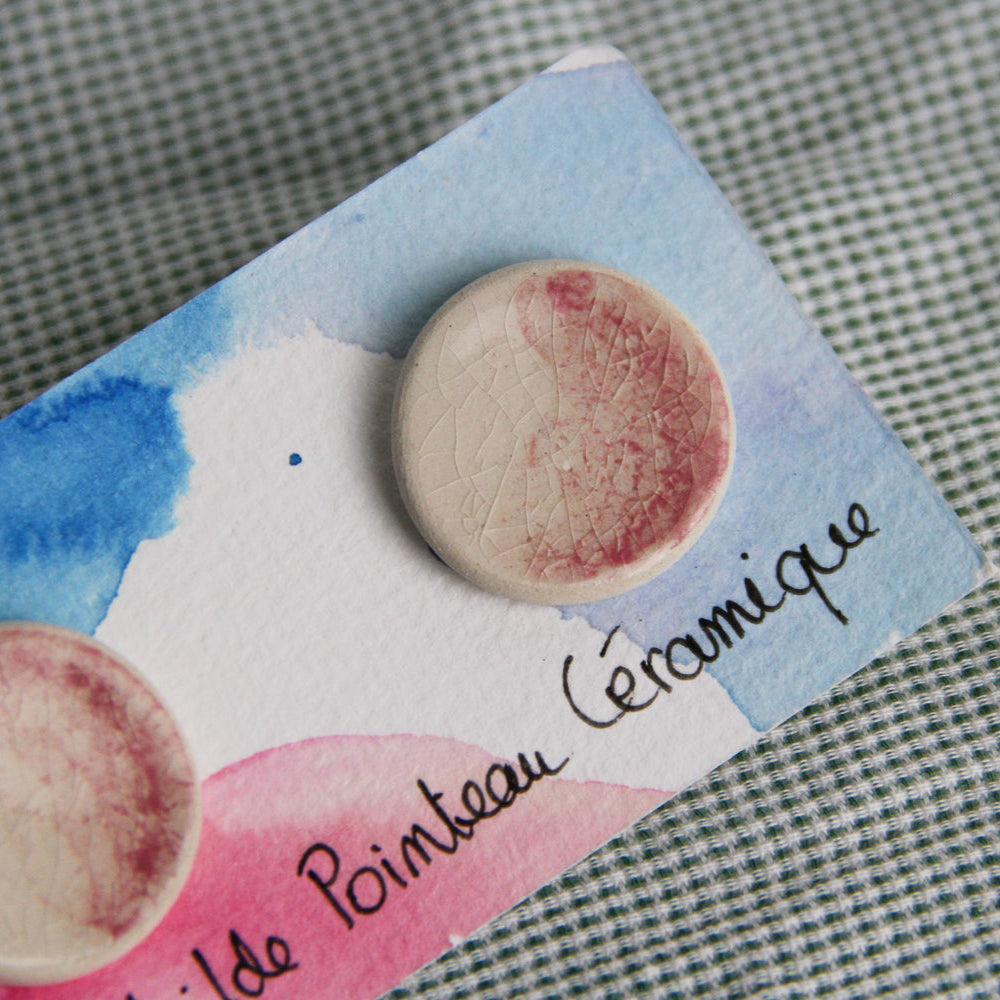 Image d'une paire de boucle d'oreille en céramique rose et craqueler.