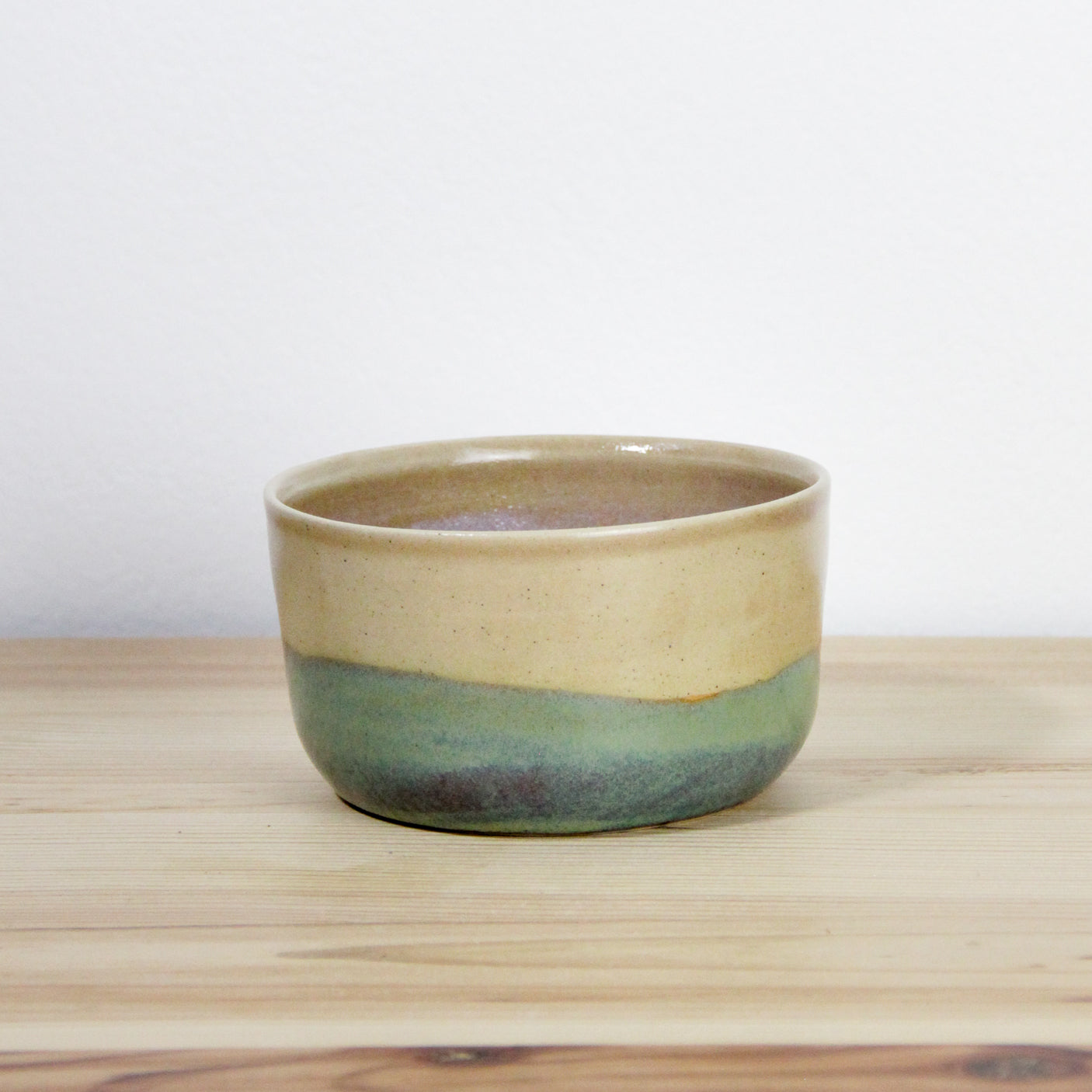 Image d'un bol en céramique artisanale vert et rose. Issue d'une fabrication française, cette pièce en grès est bicolore.