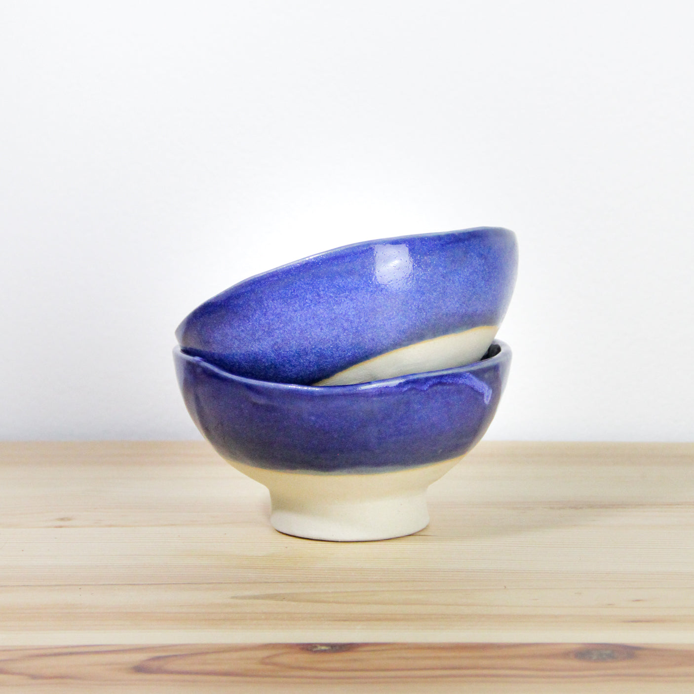 Image de deux bols à pied bleus en céramique. Vaisselle artisanale du quotidien.