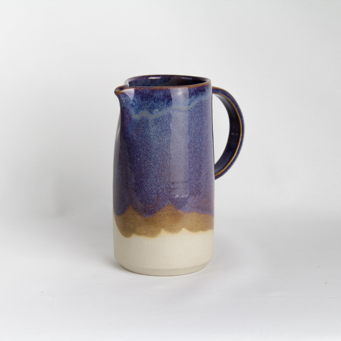 Image d'un broc à eau de hauteur 17cm avec une large anse. La pièce en céramique est de couleur violette. Idéale pour la vaisselle du quotidien.