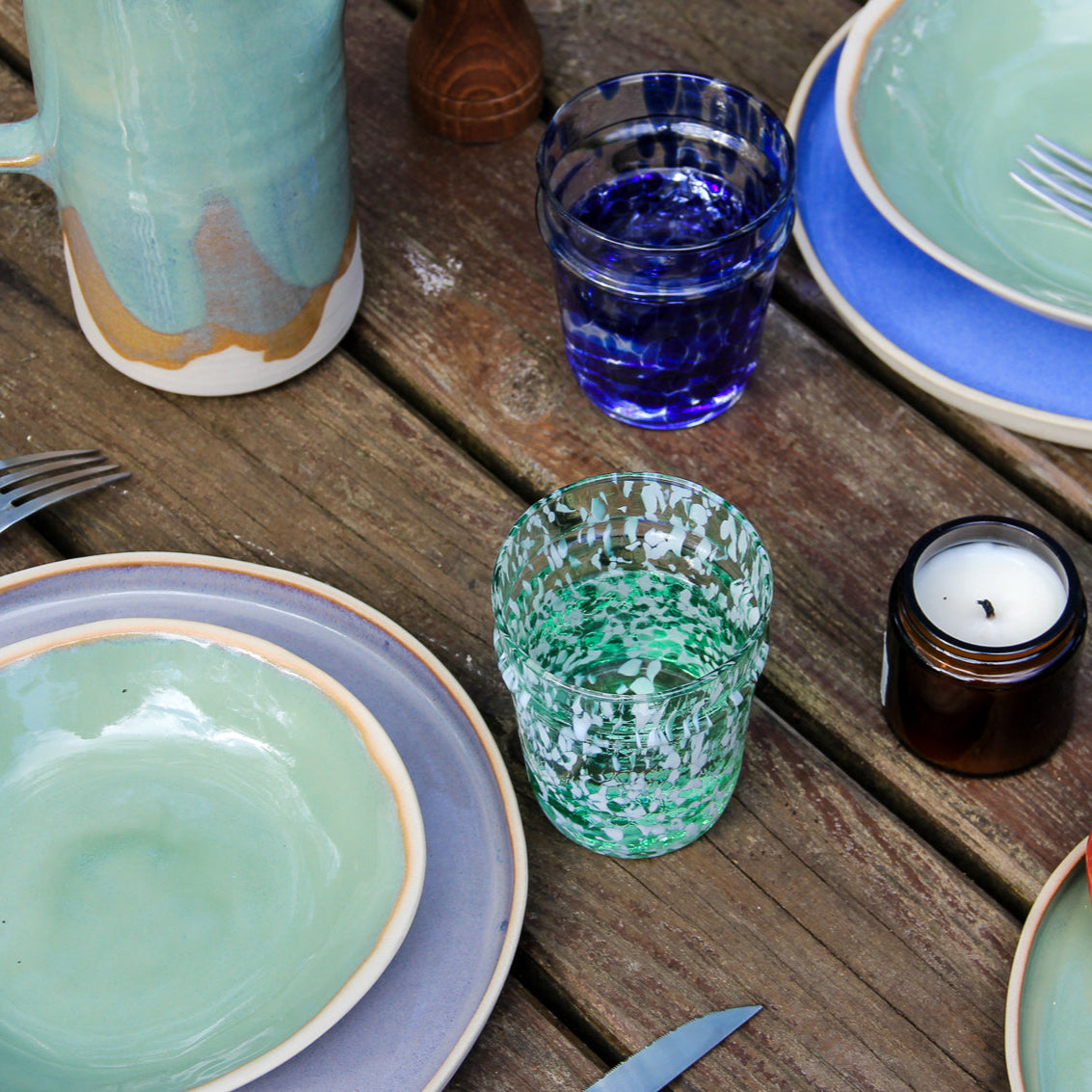 Image d'une table dressée avec des assiettes colorées.