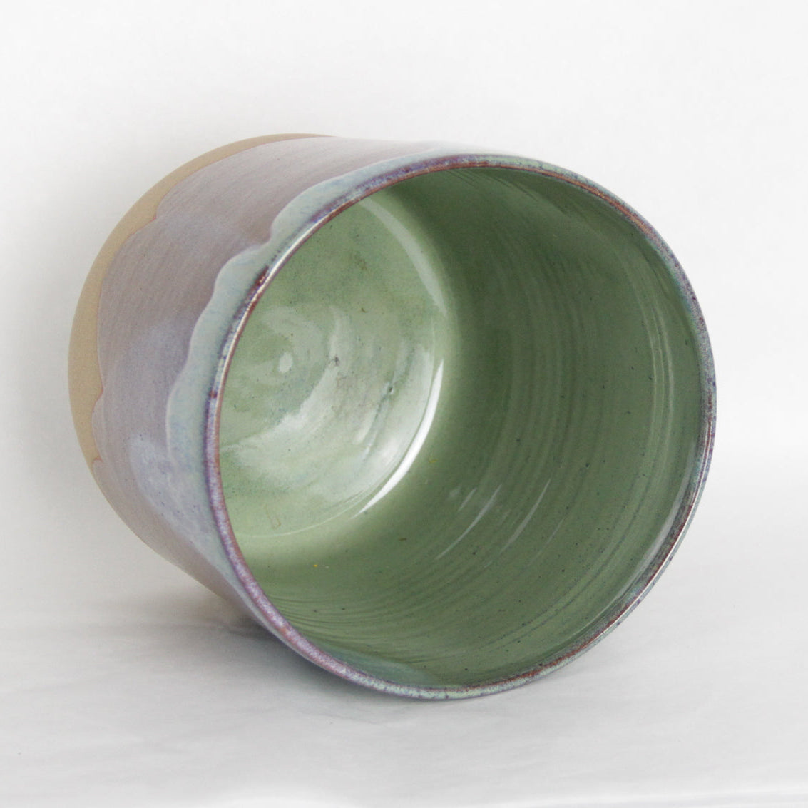 Image de l'intérieur d'un pot de fleur. Le cache-pot est de couleur verte.