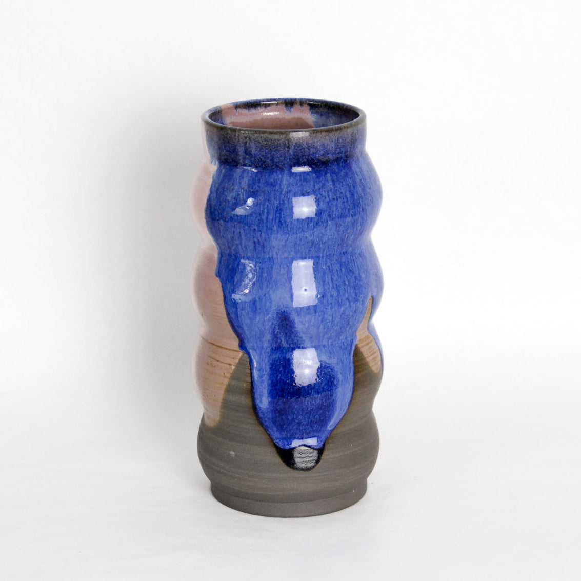 Image d'un grand vase en grès. C'est une fabrication artisanale. Les émaux sont de couleur rose et bleue.
