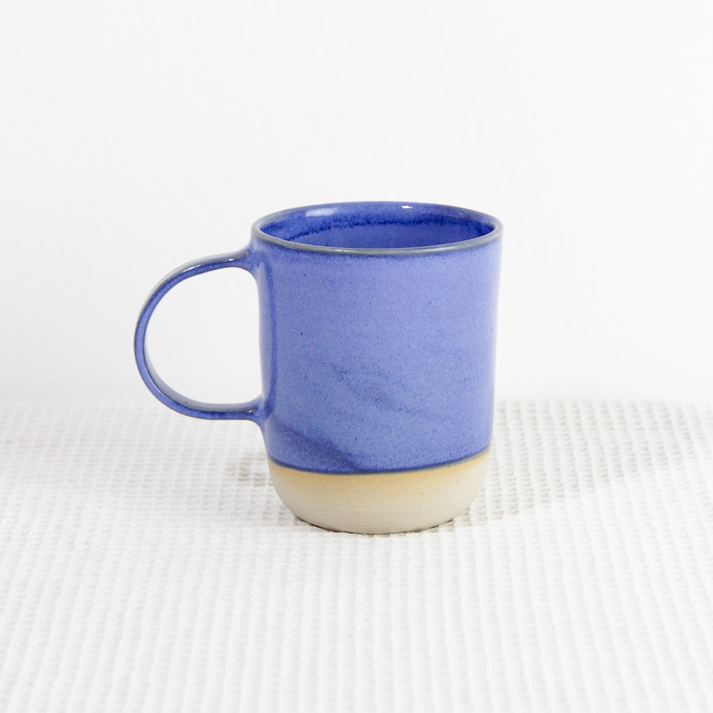 Image d'un grand mug bleu en céramique artisanale. L'anse est large et sa contenance est de 500ml.