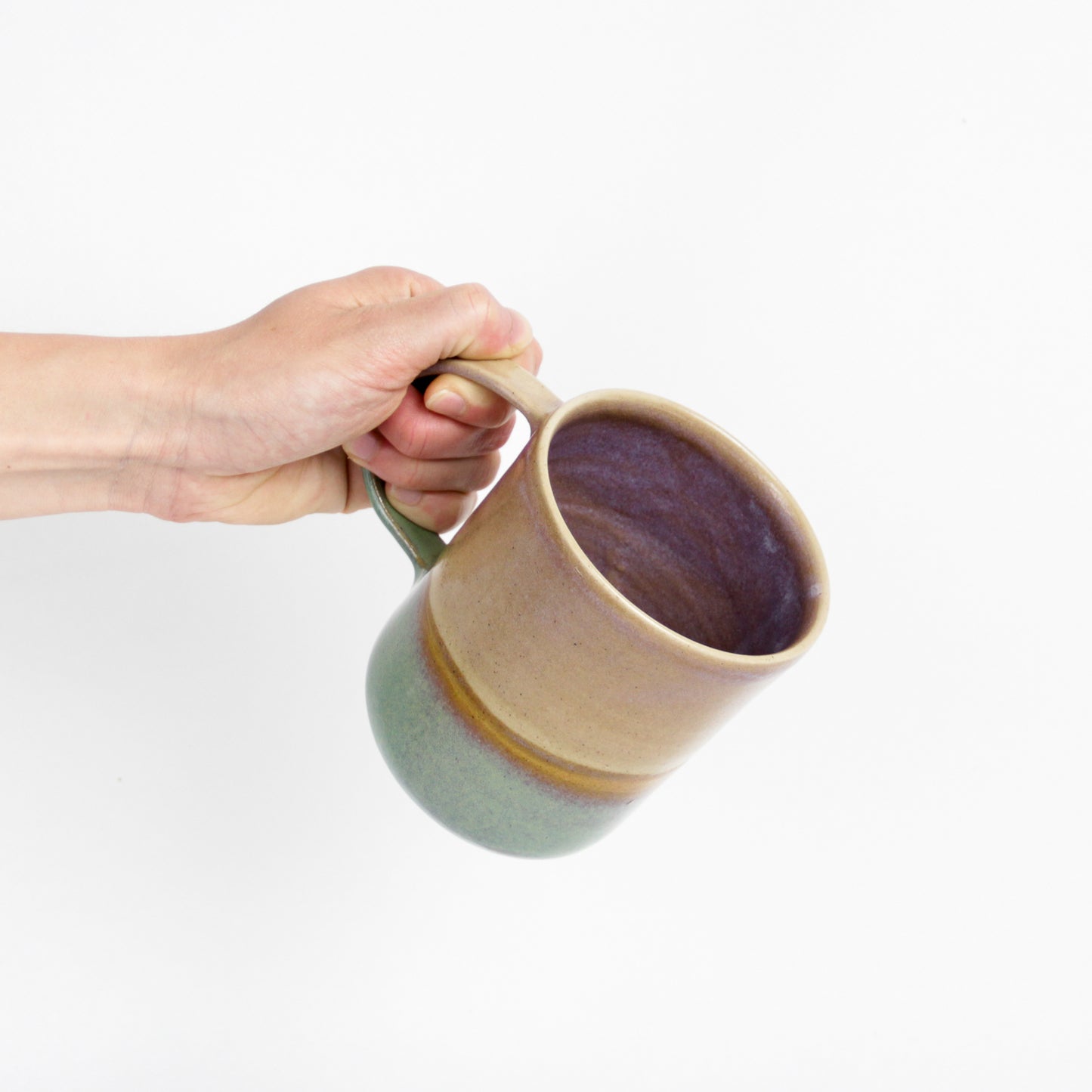 Image d'une main qui tient un grand mug en céramique de la collection paysage vert.