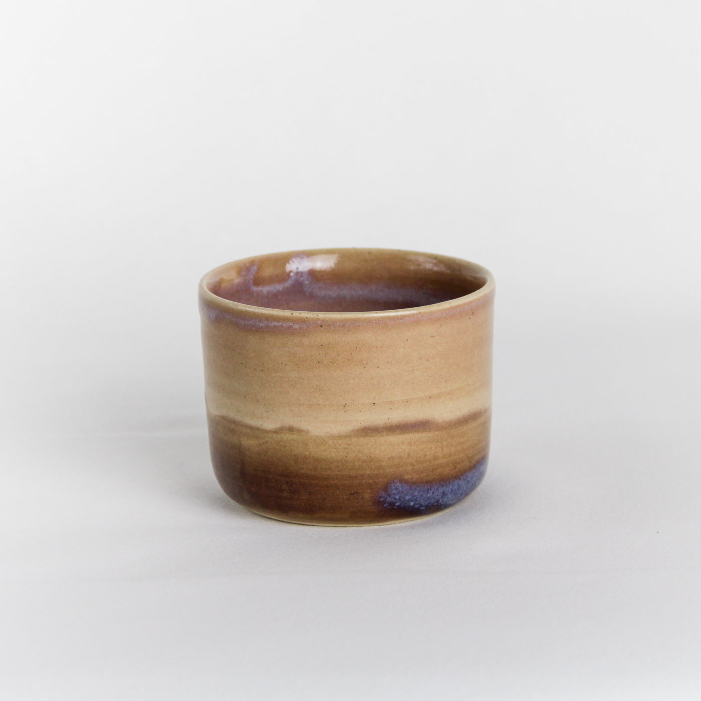 Image d'une petite tasse sans anse en céramique artisanale.