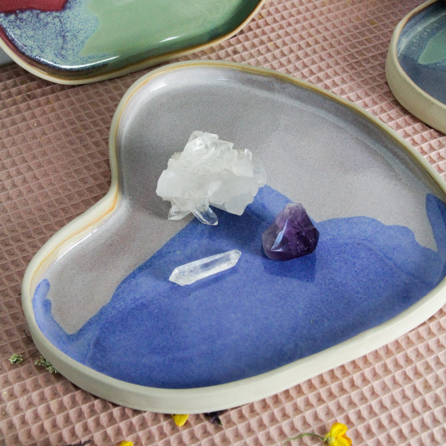 Image d'un plateau en céramique artisanale fabriqué à la main en France. Le plateau est bleu et rose et a une forme de coeur.