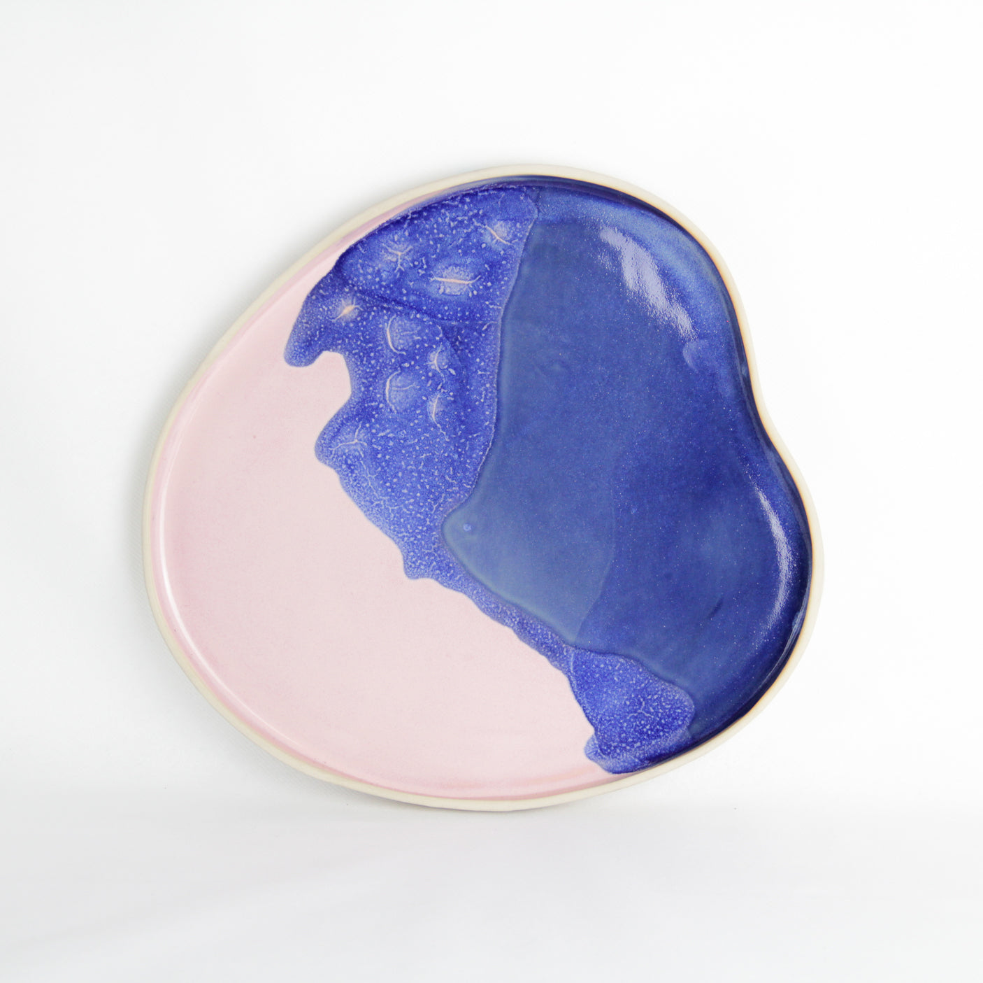 Image d'un plateau en céramique rose et bleu sur fond blanc.
