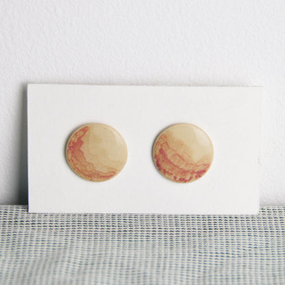 Image d'une paire de boucle d'oreille ronde et plate. Les bijoux sont en céramique