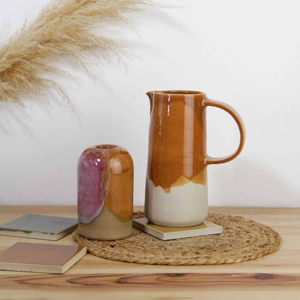 Image d'un grand pichet en céramique couleur caramel et d'un petit soliflore bicolore rose et caramel.