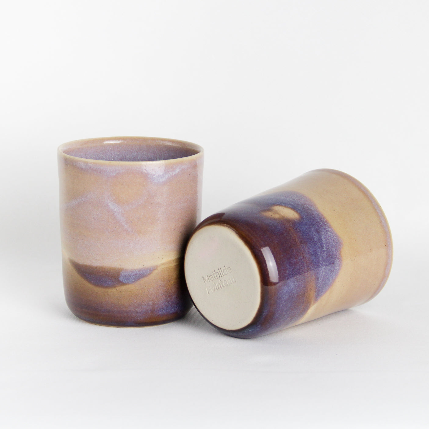 Image de deux gobelets en céramique bicolore rose et violet.