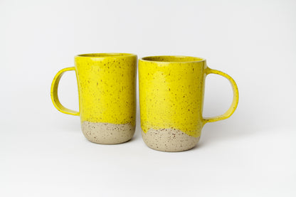 Image de deux grands mugs en céramique de couleur jaune avec une grande anse.