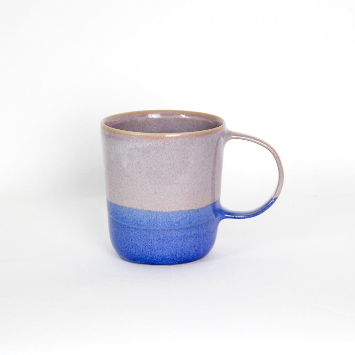 Image d'un grand mug en grès. L'anse est large et la contenance est de 500ml. La tasse est rose à l'intérieur et sur la partie haute et bleue en bas. 