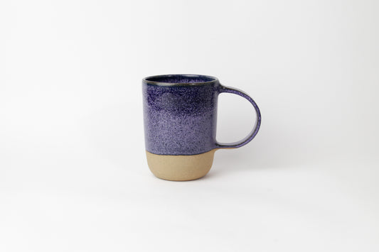 Image d'un grand mug violet sur fond blanc. L'anse est grande et la pièce n'est pas entièrement émaillée pour un effet bi-matière design et original. Mug de 500 ml. 