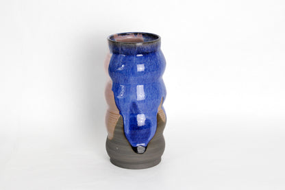 Image d'un grand vase en grès. C'est une fabrication artisanale. Les émaux sont de couleur rose et bleue.