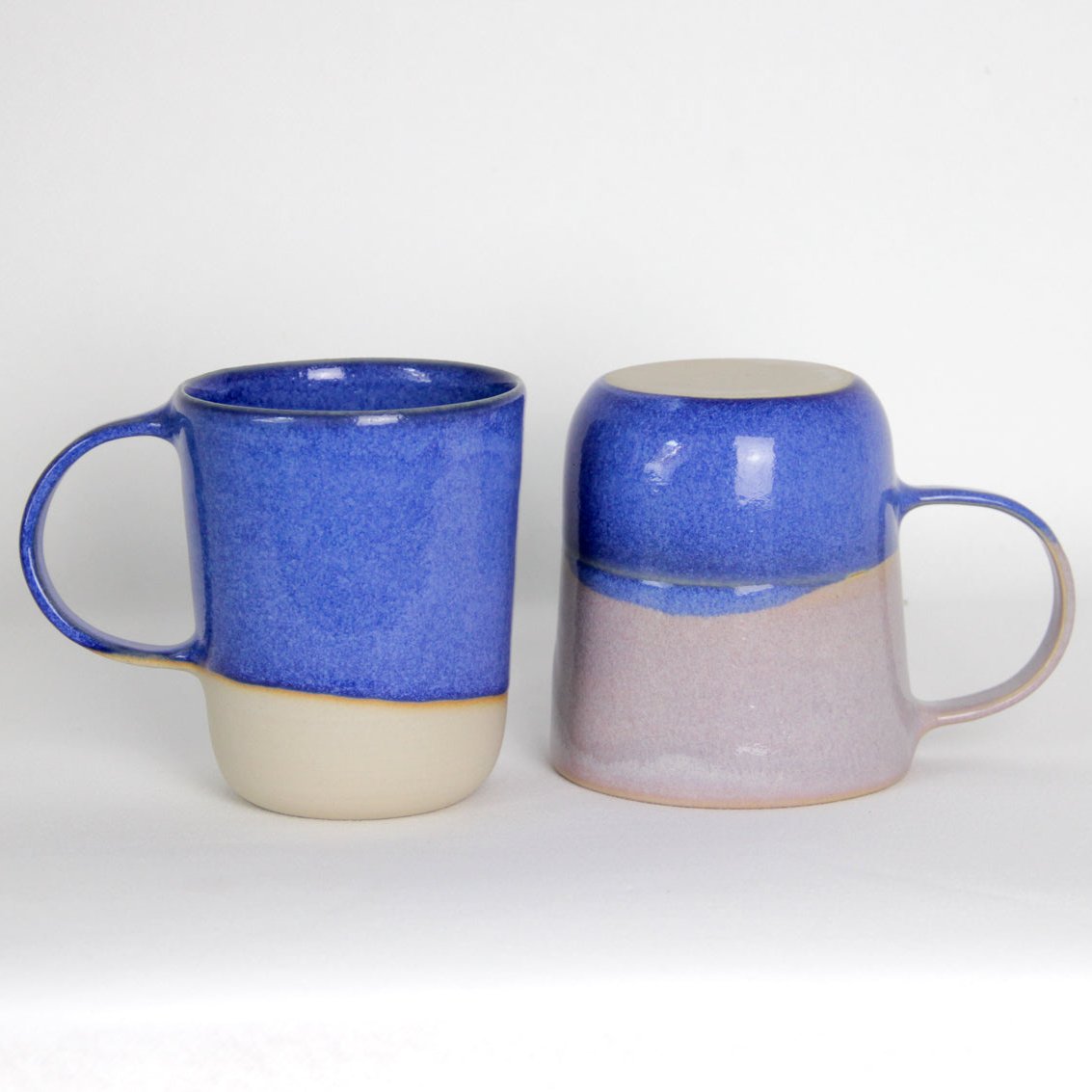 Image de deux grands mugs en céramique. L'un est bleu et l'autre est bicolore bleu et rose. Grandes anses et grande contenance de 500ml.