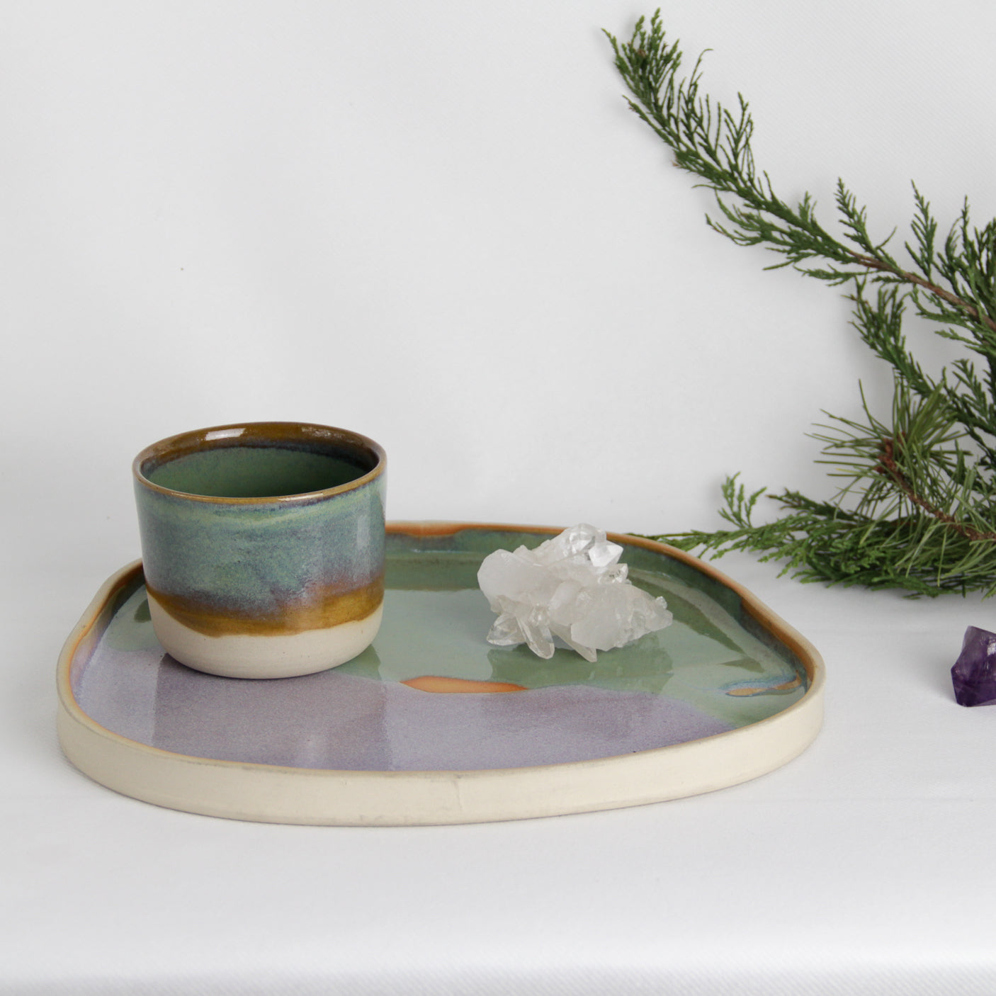 Photographie d'une petite tasse posée sur un plateau en céramique issus d'une fabrication artisanale