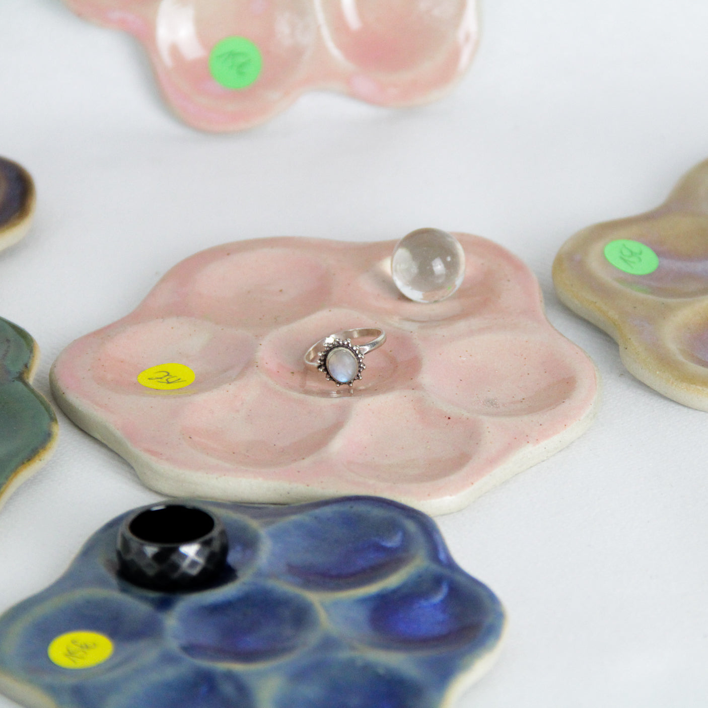 Image de petites marguerites en céramique qui servent de support à bijoux et cristaux.