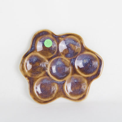 Image d'une marguerite en céramique de couleur violette avec des nuances. C'est un objet décoratif.