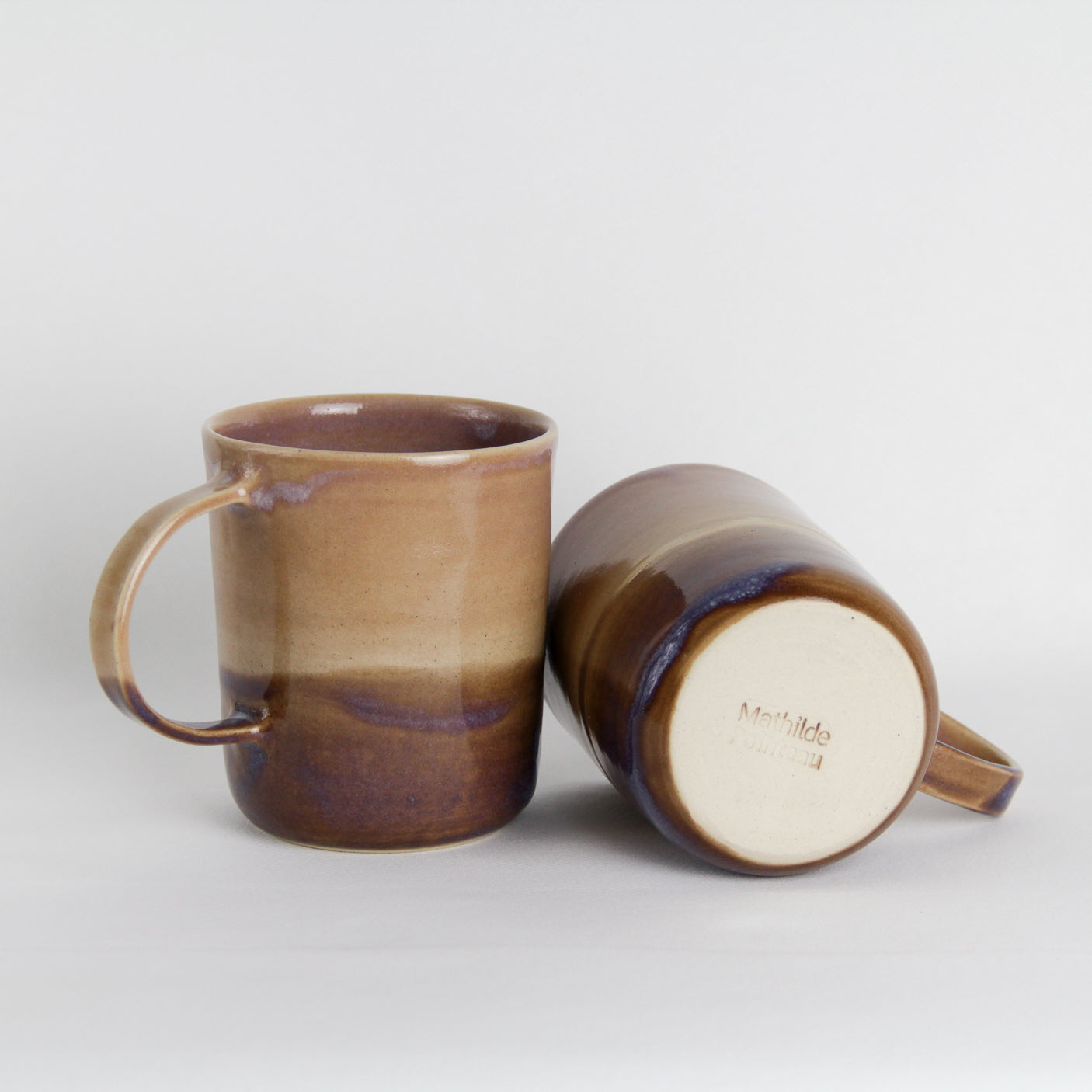 Image de deux mugs en céramique bicolore. Ils ont tous les deux une large anse.