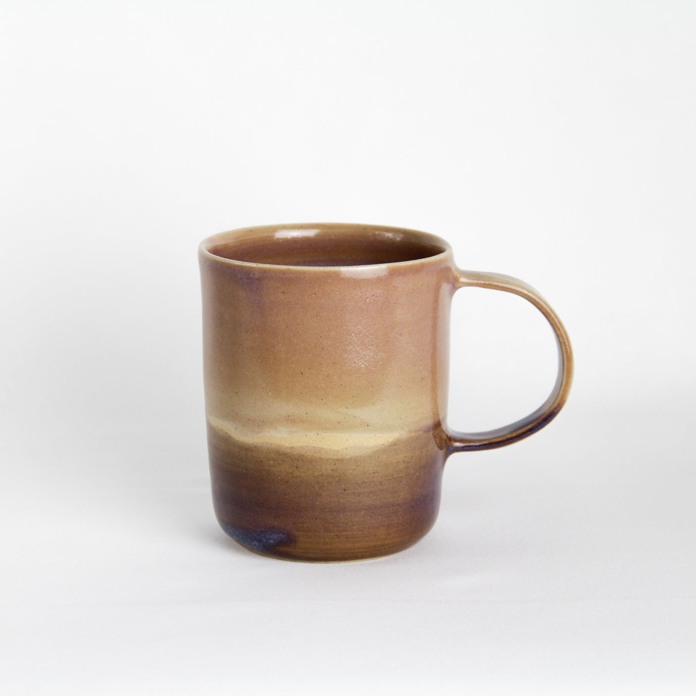 Image d'un grand mug en grès sur fond blanc. L'anse est large.