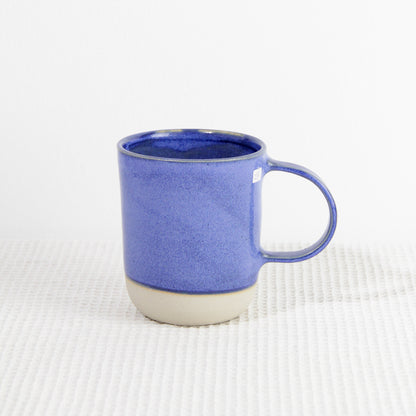 Image d'un grand mug bleu en grès. L'anse est large. Sa contenance est de 500ml. 