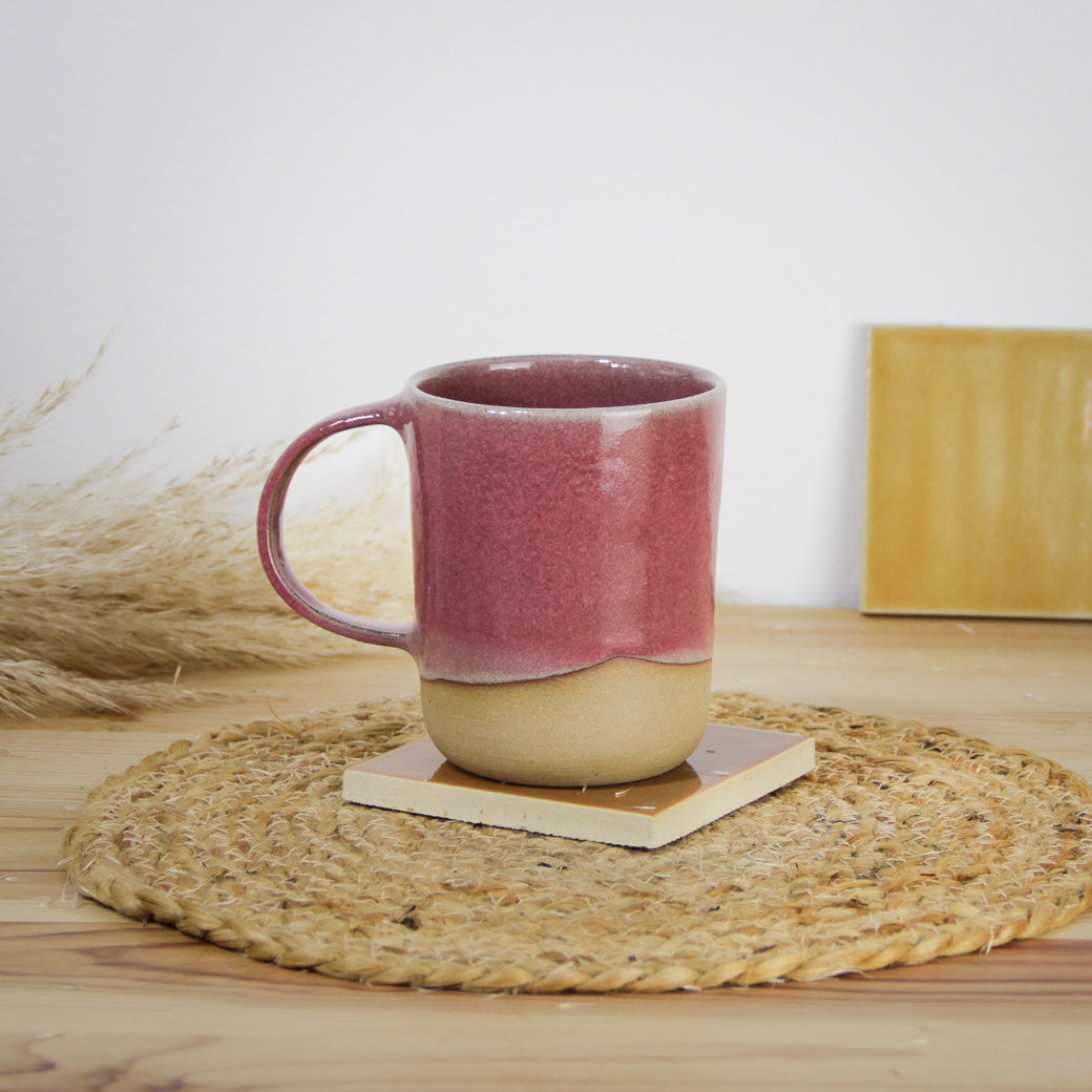 Image d'un grand mug rose en céramique artisanale, l'anse est large et le bas de la pièce n'est pas émaillé pour un effet bi-matière unique.