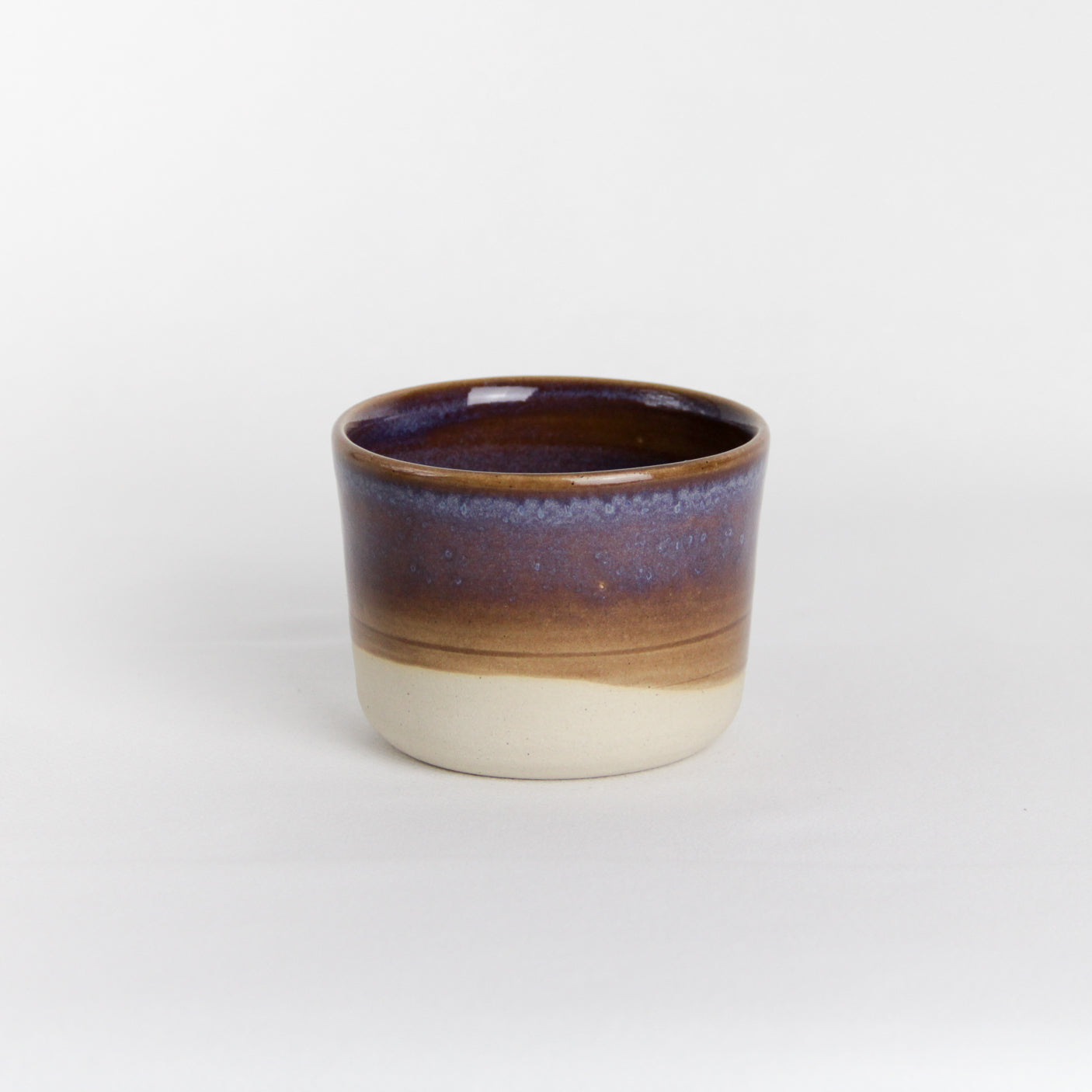 Image d'une petite tasse en céramique sans anse. La partie basse de la pièce n'est pas émaillée.