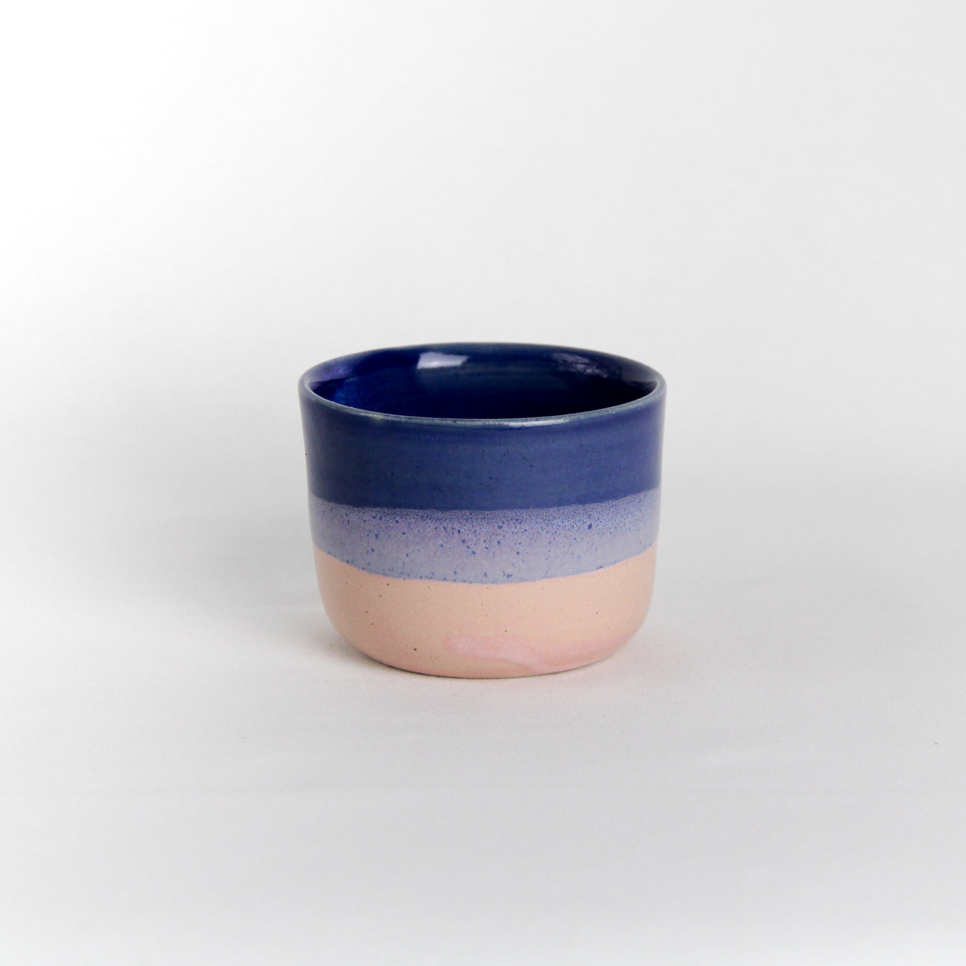 Image d'une petite tasse rose et bleue en céramique. Vaisselle du quotidien, idéale pour un petit café.