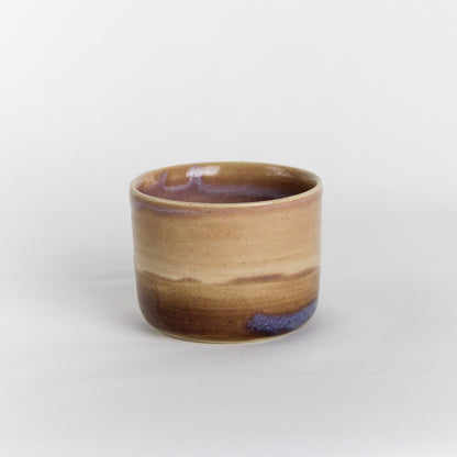 Image d'une petite tasse sans anse en céramique artisanale.