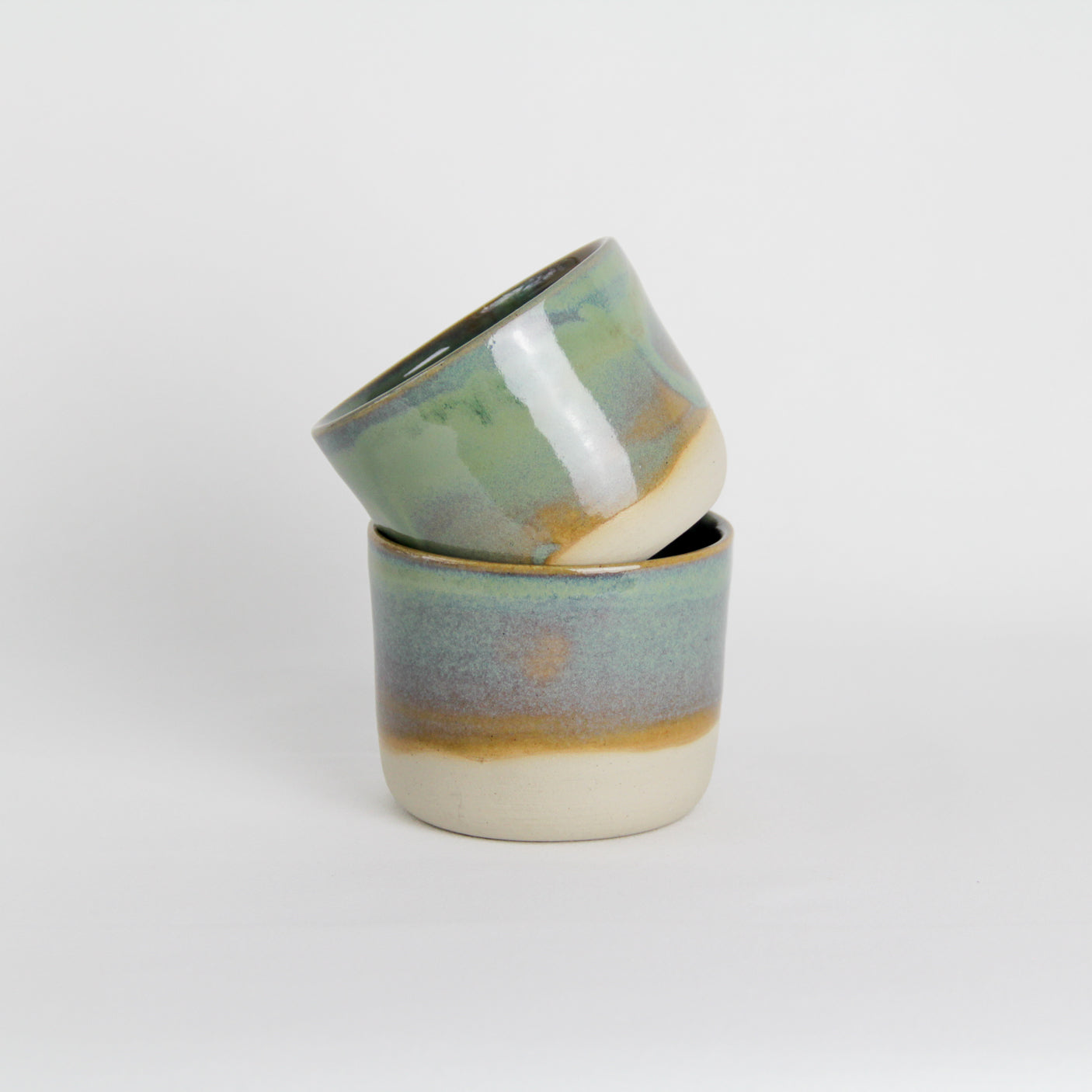 Image de deux tasses émaillées en vert. Ce sont des petites tasses à café pour le quotidien.