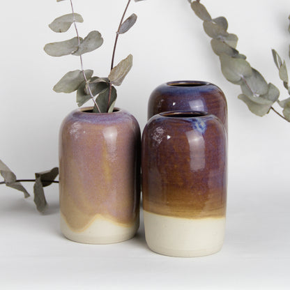 Image de trois petits vases de table en céramique style soliflore dans les tons de violet / rose avec des branches d'eucalyptus. Ils sont fabriqués à la main.